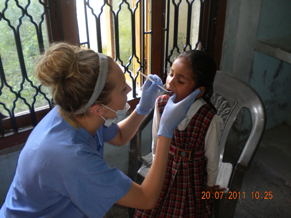 A dental elective intern examining a kid
